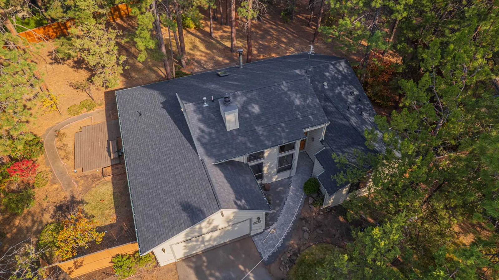 Aerial view of the finished composition shingle roof on a wooded Bend, Oregon property